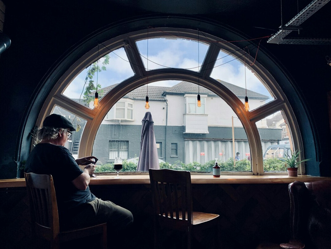 Woman writing thoughtfully in a journal near a window